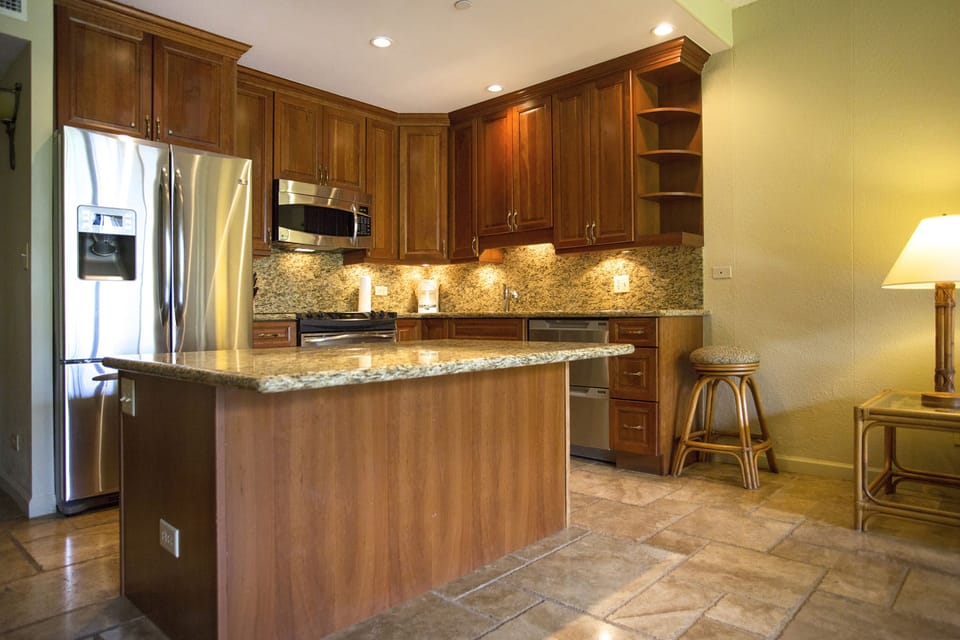 You'll love the fully equipped kitchen featuring granite counters, rich wood cabinetry, and modern stainless appliances. Perfect for preparing your favorite meals while on vacation.