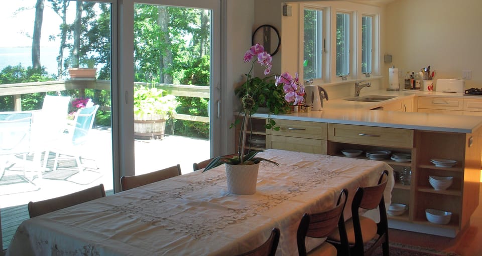 dining room table with panoramic views of the harbor and passing sailboats
