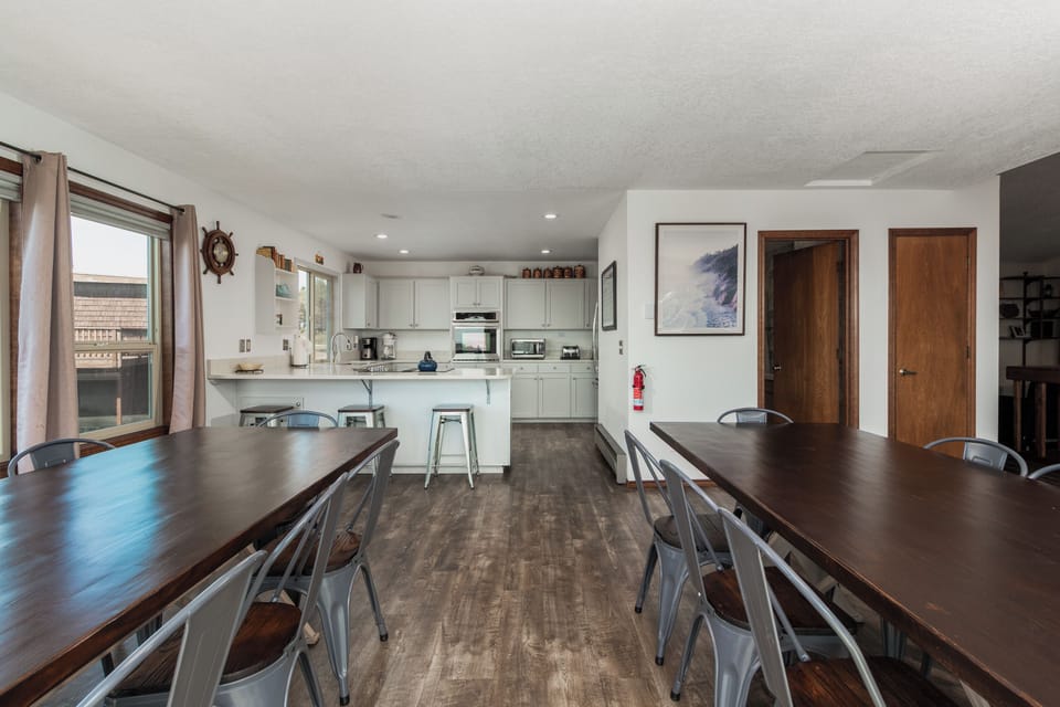 A bright, open space where your group can gather around welcoming dining tables. The adjoining kitchen offers everything you need to prepare meals together and enjoy the natural light streaming in.