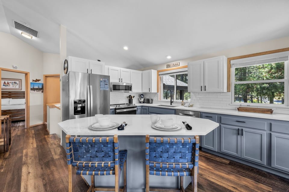 Your spacious kitchen invites you to gather and create, with a large island and natural light streaming through the windows overlooking the trees outside.
