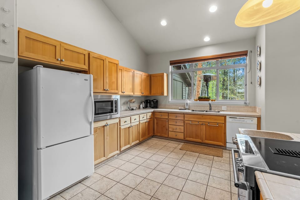 Step into this bright, fully-equipped kitchen where your morning coffee will taste even better with serene forest views from the window and all the space you need to whip up a family meal.