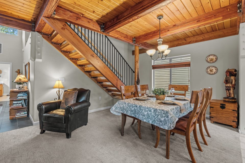 Relax in this open-concept space where rustic warmth meets modern comfort—your gathering spot under soaring wood-beamed ceilings, perfect for meals and conversation with loved ones.