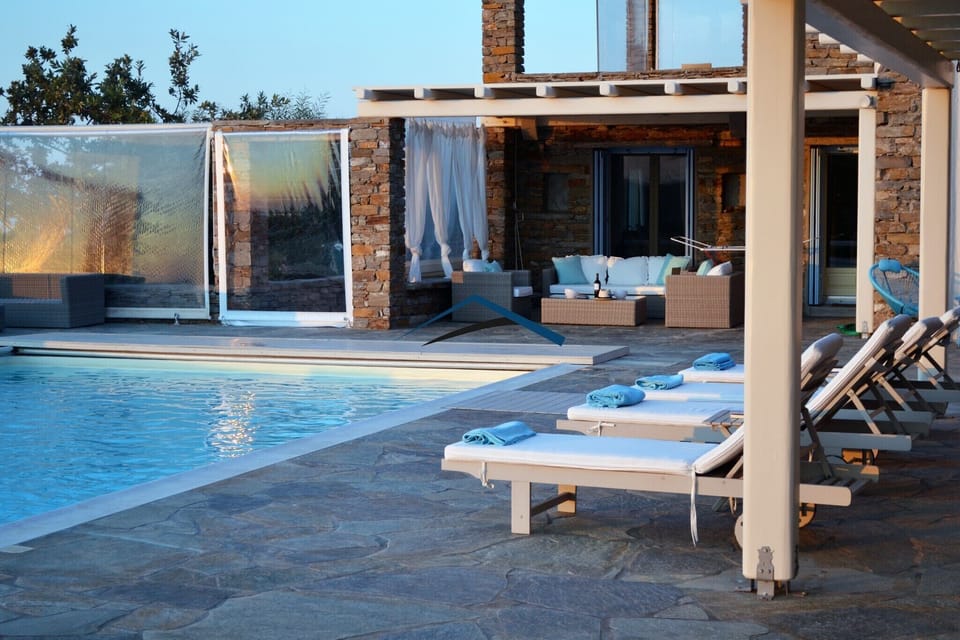A seating area near the pool and some of the sunbeds