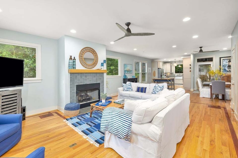 Spacious living area with white furniture and fireplace