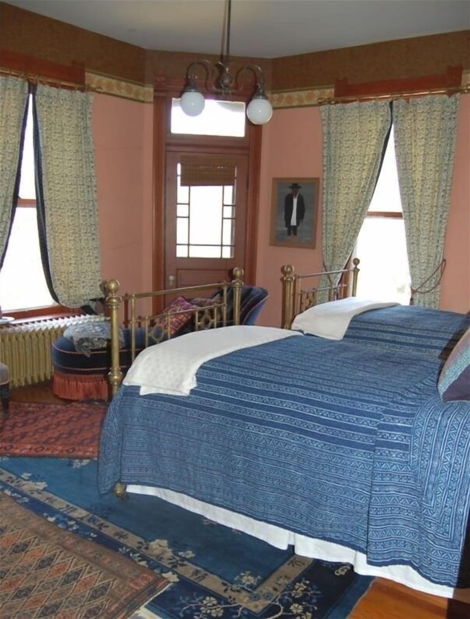 The Turret Bedroom contains a chaise longue, as well as antique twin brass beds.