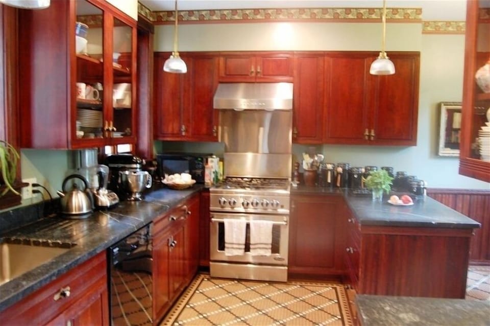 The kitchen features soapstone counters, a deep sink, and a 5-burner gas range.