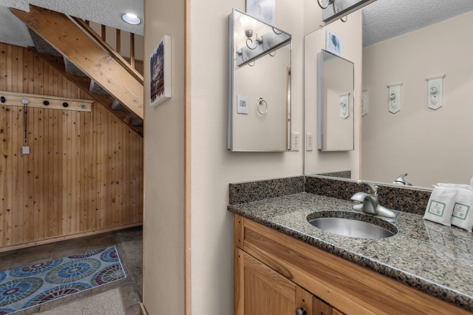 Step into your private retreat with a spacious granite vanity, double mirror setup, and warm wood finishes that blend rustic charm with modern convenience.