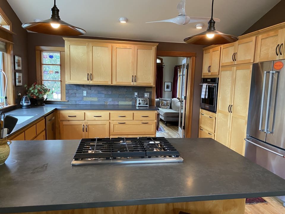 gorgeous kitchen with quartz counters and an induction stovetop, well equipped
