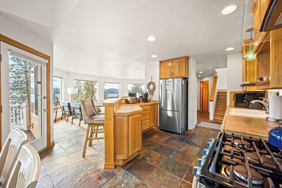 Your gourmet kitchen features warm wood cabinetry and premium appliances, perfect for creating memorable meals during your mountain getaway.