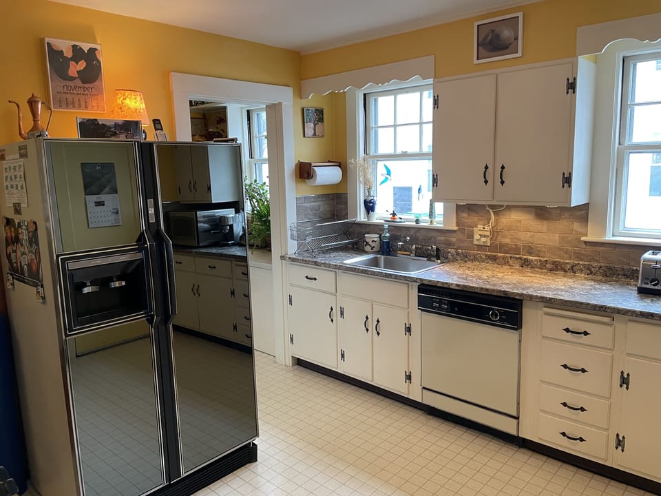 Kitchen has Large Fridge, Dishwasher, New Counters & Tile Backsplash