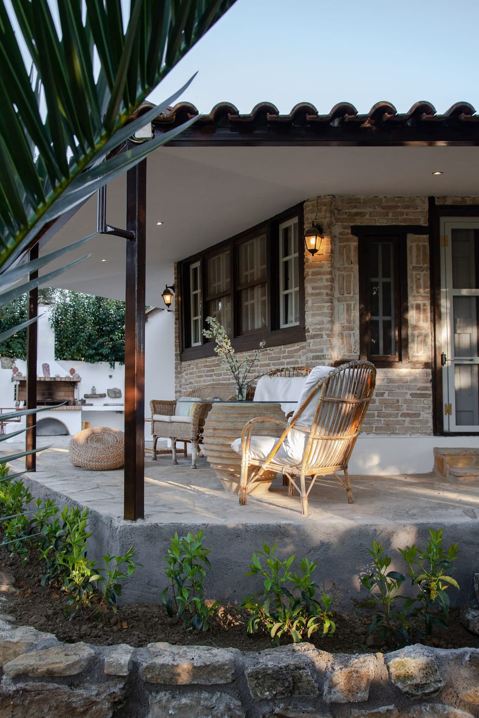 @ the terrace there are 2comfortable baboo chairs a sofa and a table from glass 