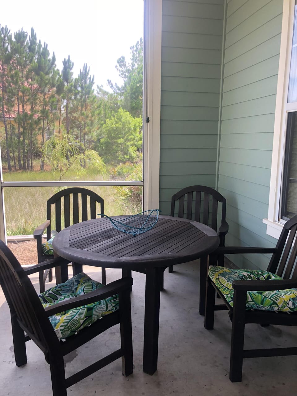 Screened porch with dining table and rocking chair.  (and ceiling fan!!)