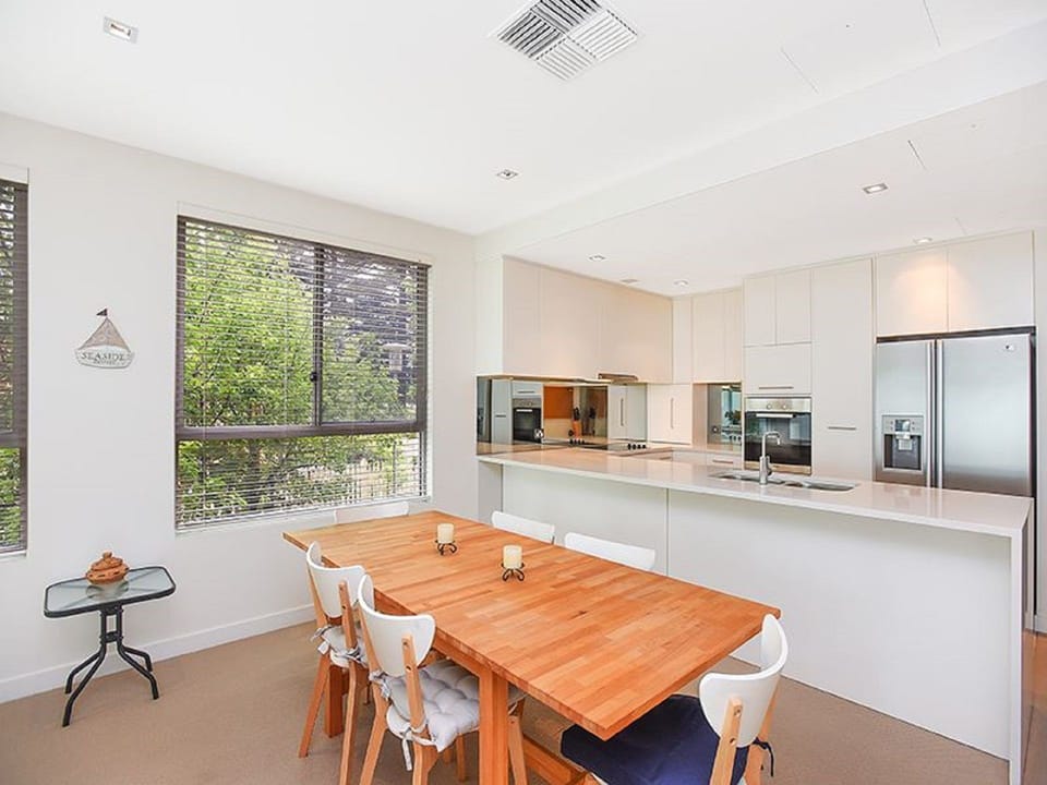 Fully equipped kitchen with modern appliances including stovetop, oven, microwave, full-sized fridge, kettle, toaster, and dishwasher.