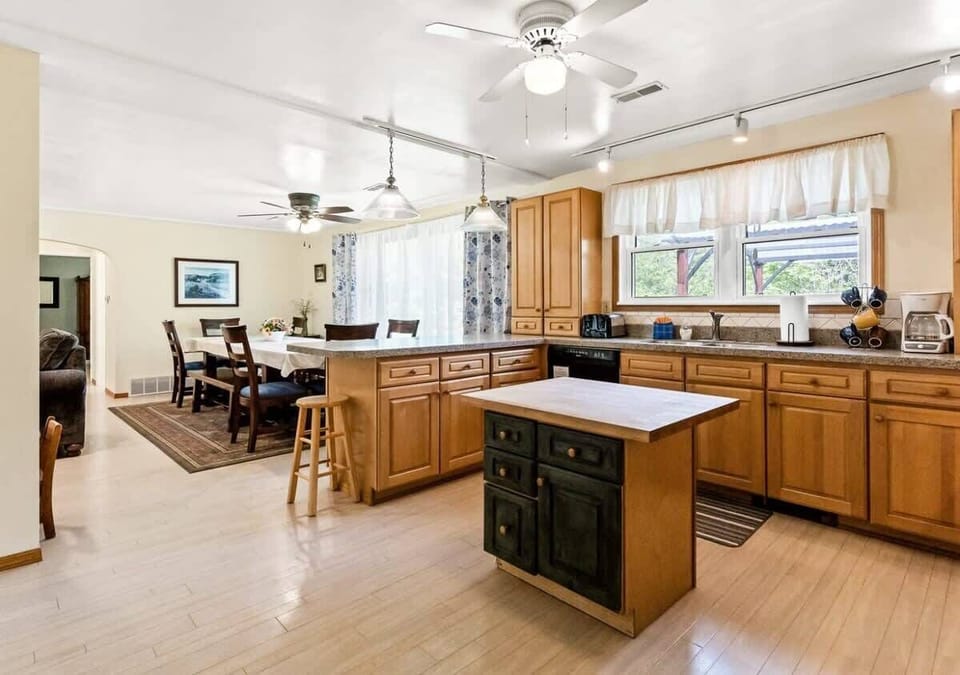 Big open White Oaks Haven kitchen with lovely light oak cabinetry, small butcher block island, and plenty of light