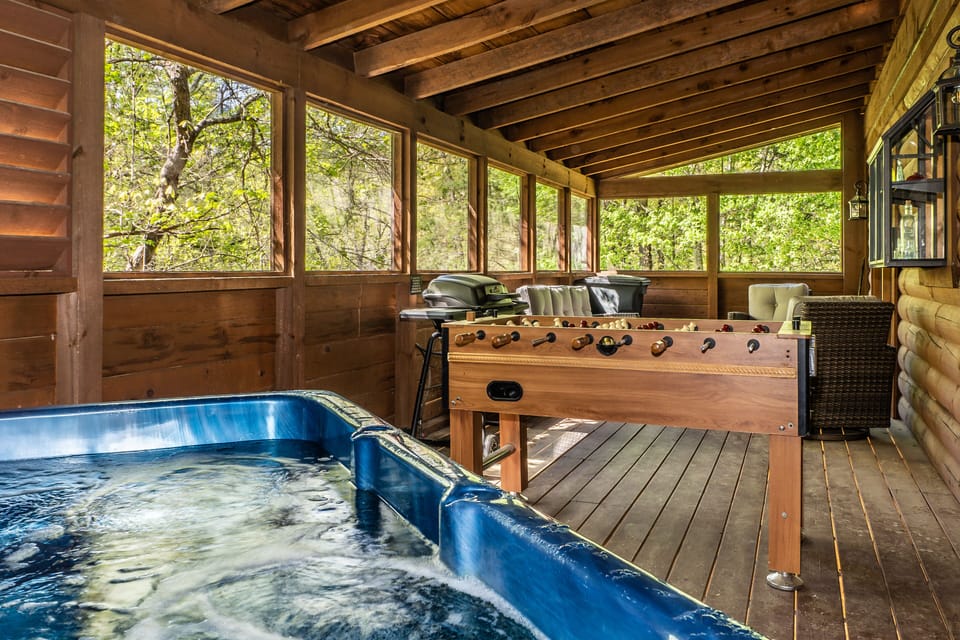 Screened deck includes hot tub, foosball, gas grill, games, and seating for four