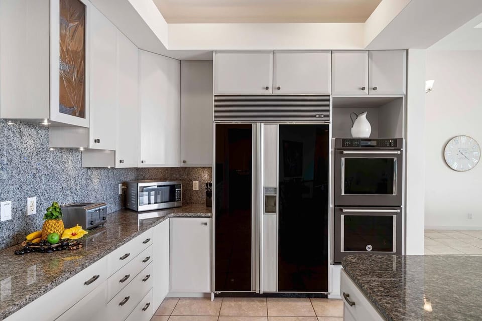 Kitchen with built-in refrigerator, double oven, and granite countertops.