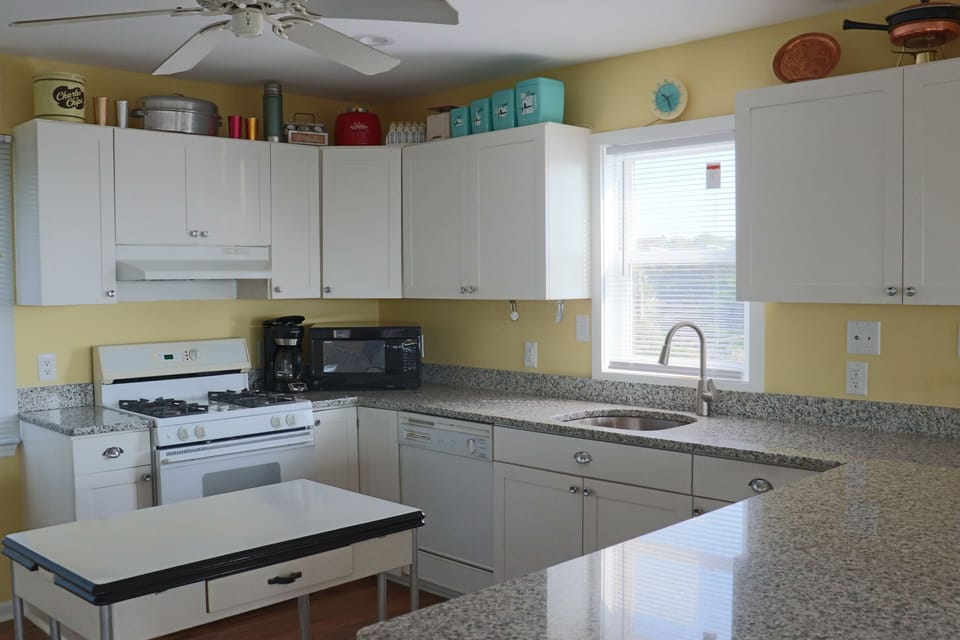 Whip up your favorite meals in this bright, fully-equipped kitchen with ample counter space and cheerful yellow walls.