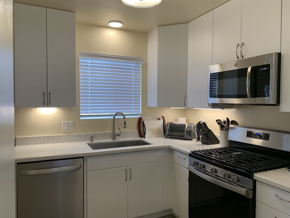 Gas stove, farmsink and stainless dishwasher and microwave.