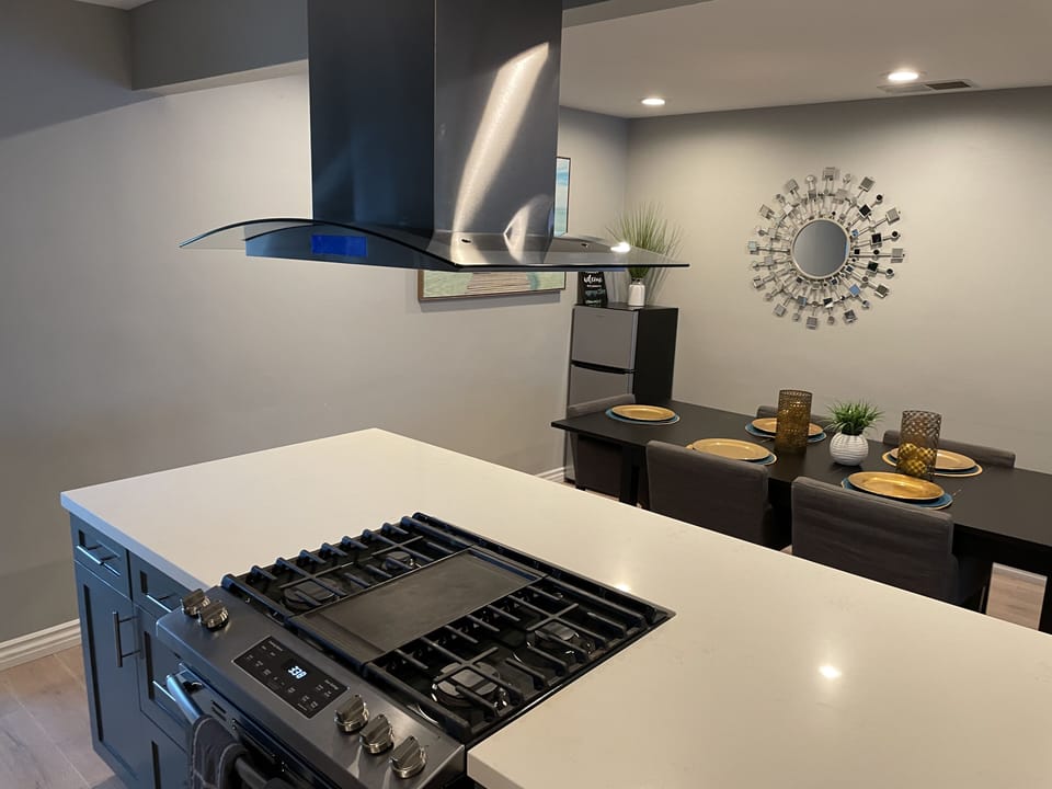 Gas stove burners, within open island designed kitchen. 
