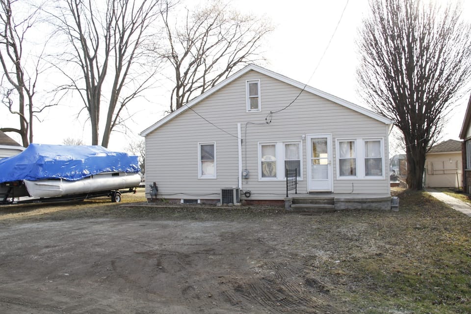 back of house and driveway with ample parking