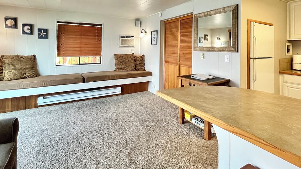 Living room with two daybeds approximately twin size, and the bedroom is off to the right - louvered door is closed
