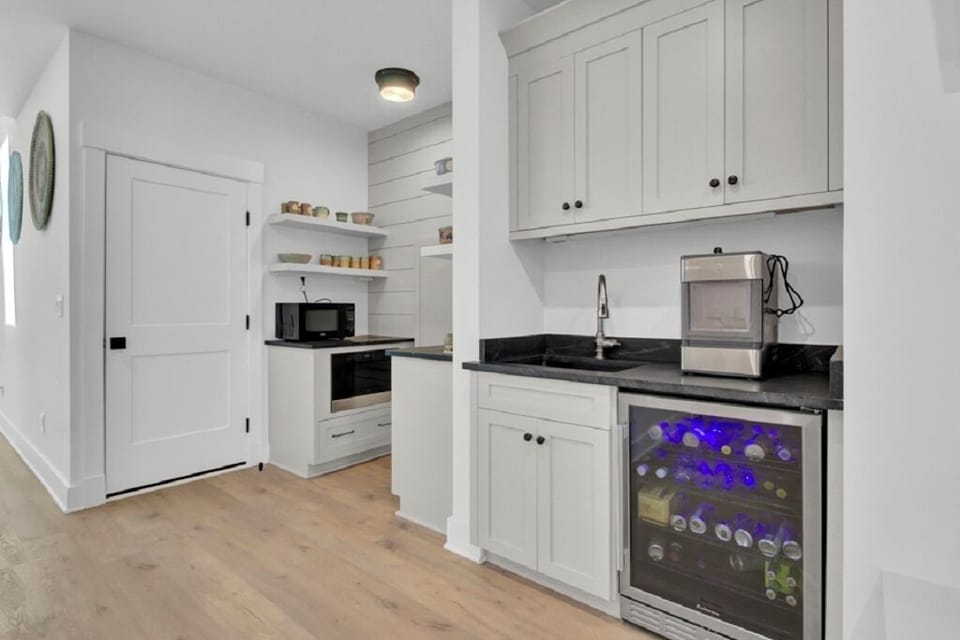 - Stocked mini fridge, ice maker, and sleek black counters create a stylish refreshment zone - Open shelves and built in microwave make snack prep quick and easy - Great for morning coffee, evening cocktails, or anytime in between