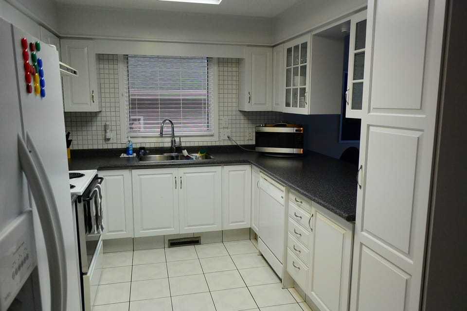 Bright open-concept fully equipped kitchen looking onto dining area.