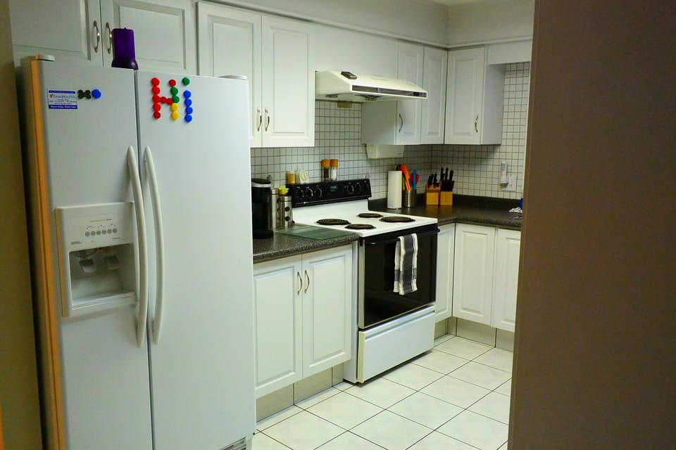 Bright open-concept fully equipped kitchen looking onto dining area.