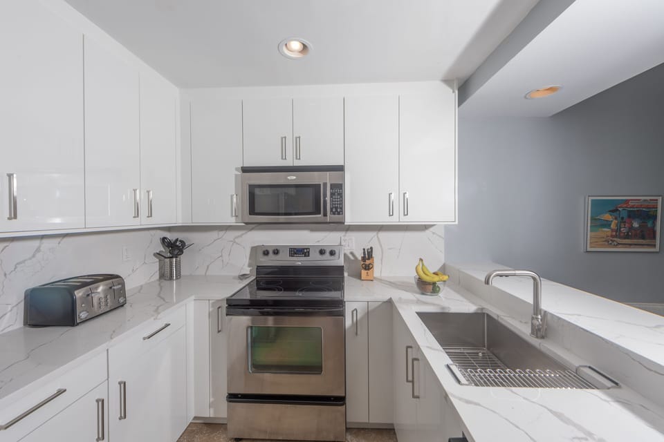Fully stocked kitchen: dishes, flatware, glasses, coffee maker, toaster, blender
