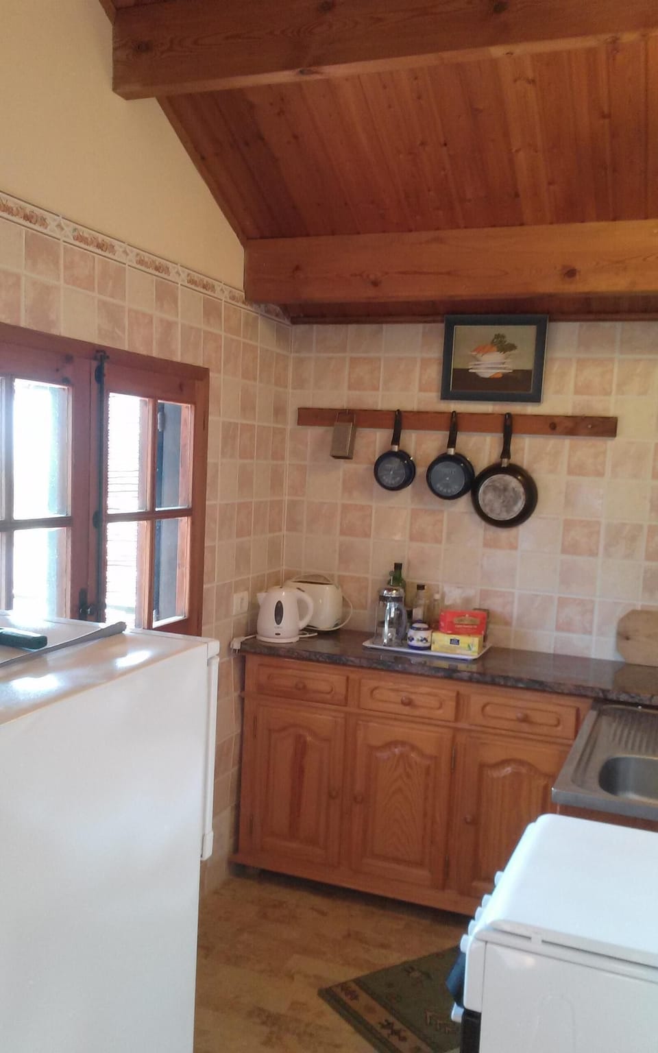 Lodge equipped kitchenette, with service window onto dining terrace. 