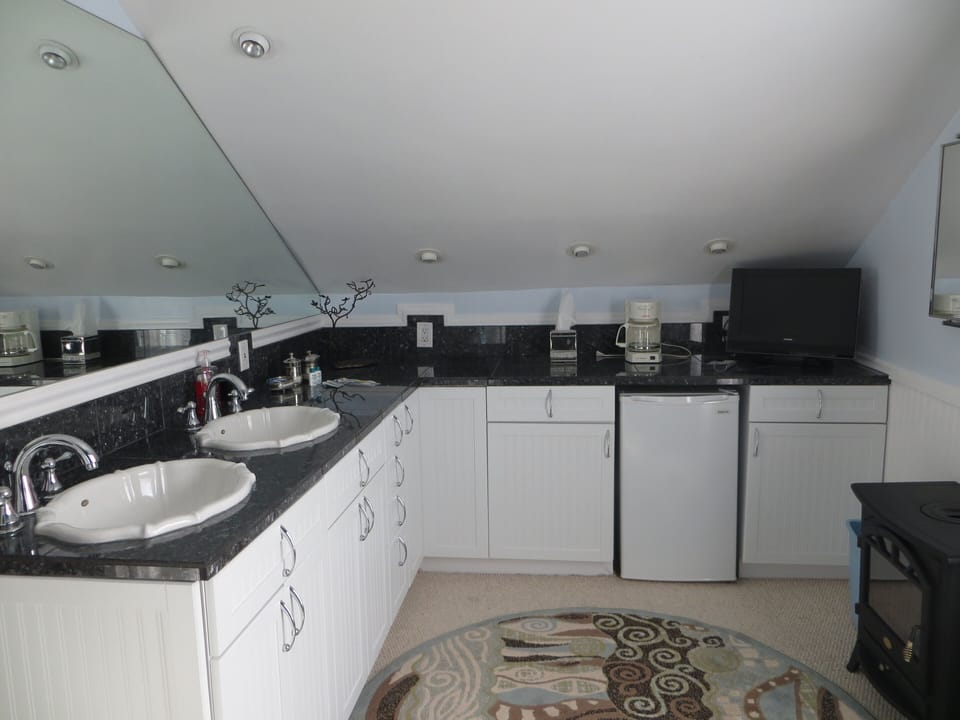 Master bedroom with 2 sinks, mini=fridge, coffee maker, and tv.