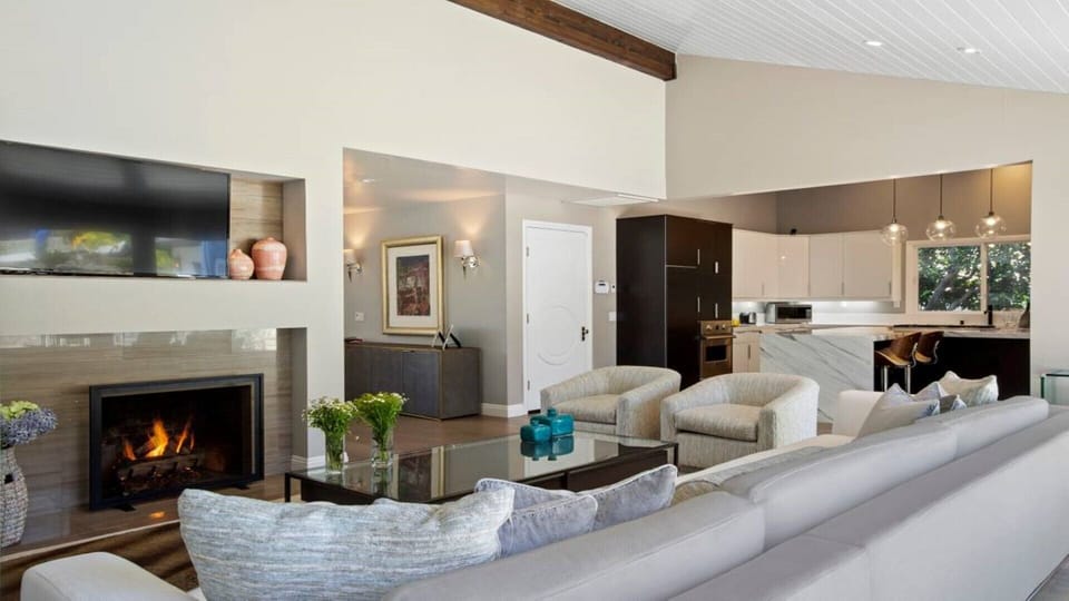 open living room leading to yard most furnishings are restoration hardware, hardwood fl;doors and marble details, large sliding doors, hall way leads to kids room and master bed room in front is the marble kitchen island for breakfast