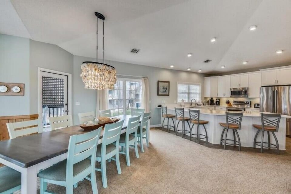 This bright, open-concept space blends dining and kitchen areas perfectly. Gather around the elegant table or chat at the breakfast bar while meals come together.