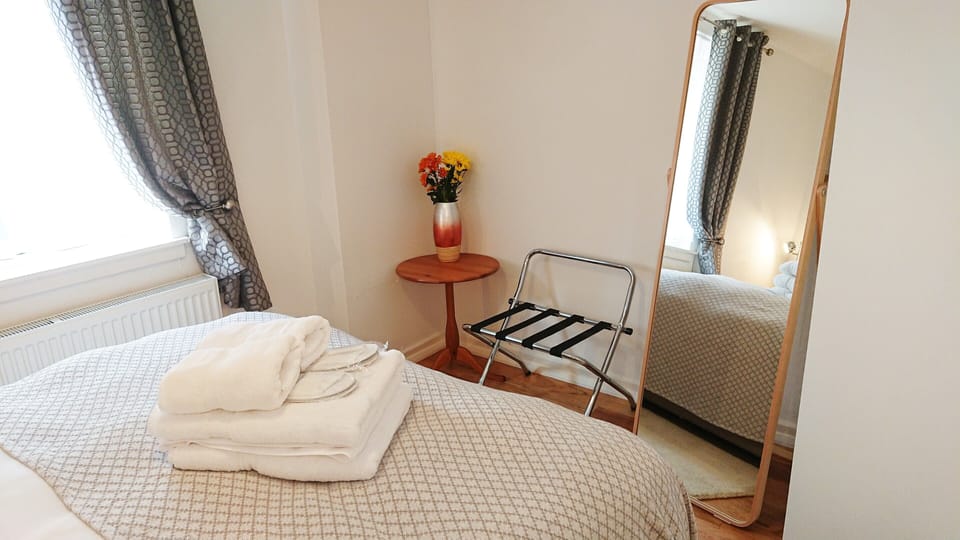 Double bed room with luggage rack and full length mirror.