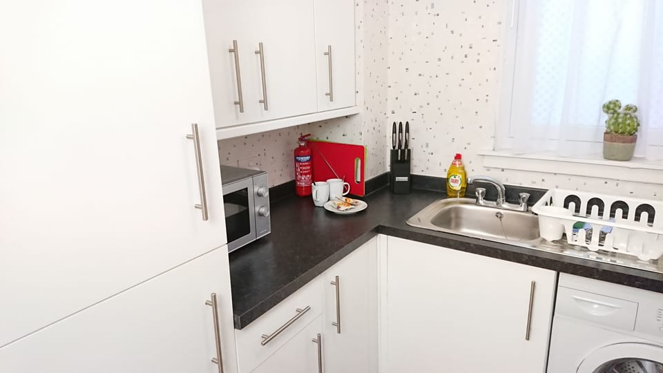 Kitchen with microwave, tea & coffee facilities, cleaning products.