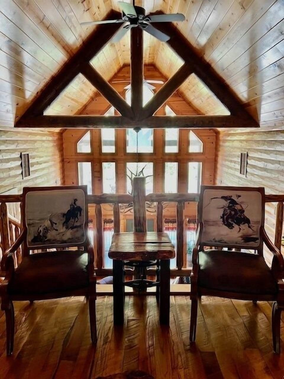 Unwind in this cozy loft seating area, where rustic wood beams and expansive windows create a peaceful retreat with a view.