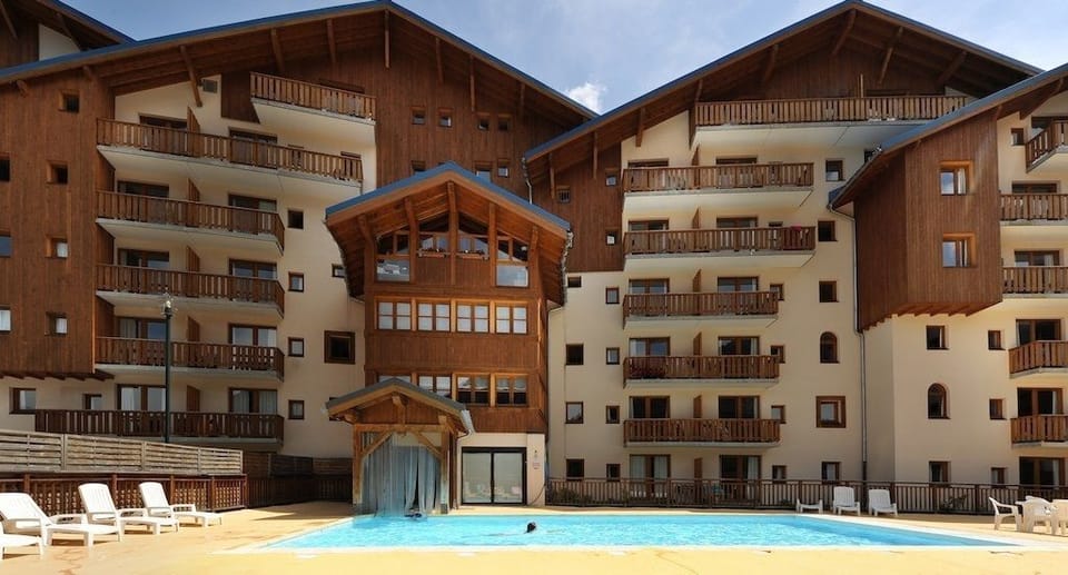 Dive into relaxation at the pool, where clear waters await under a blue sky.