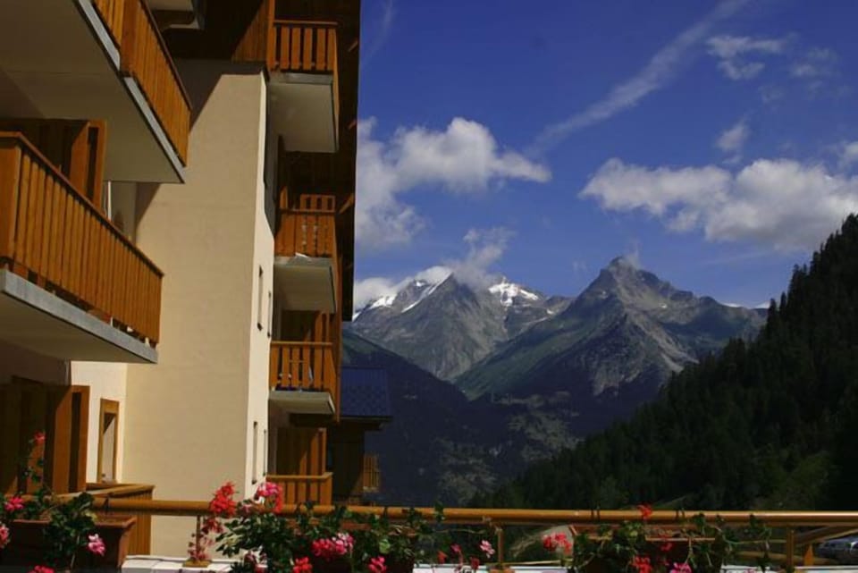 Witness breathtaking mountain peaks rising majestically in the clear blue sky, creating a picturesque escape.