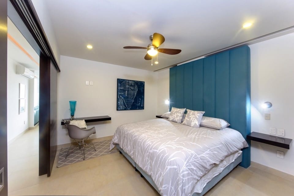King-sized bed. TV has been installed over desk area.