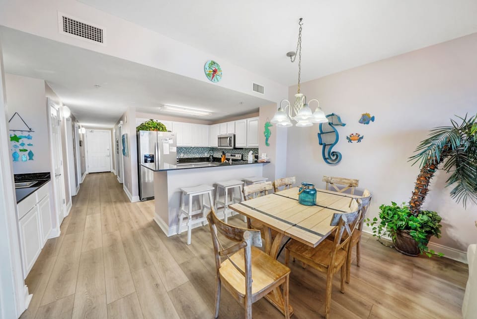 Relax in your bright, coastal-themed space with open kitchen, dining table for six, and tropical touches that make every meal feel like vacation.