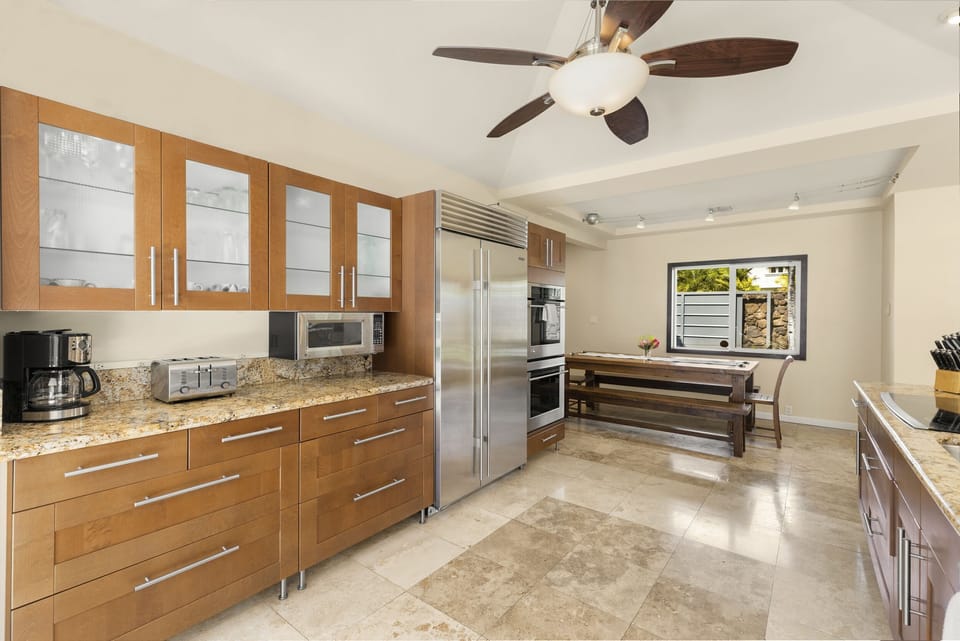 Spacious kitchen with granite counters, warm wood cabinetry, and an open layout.
