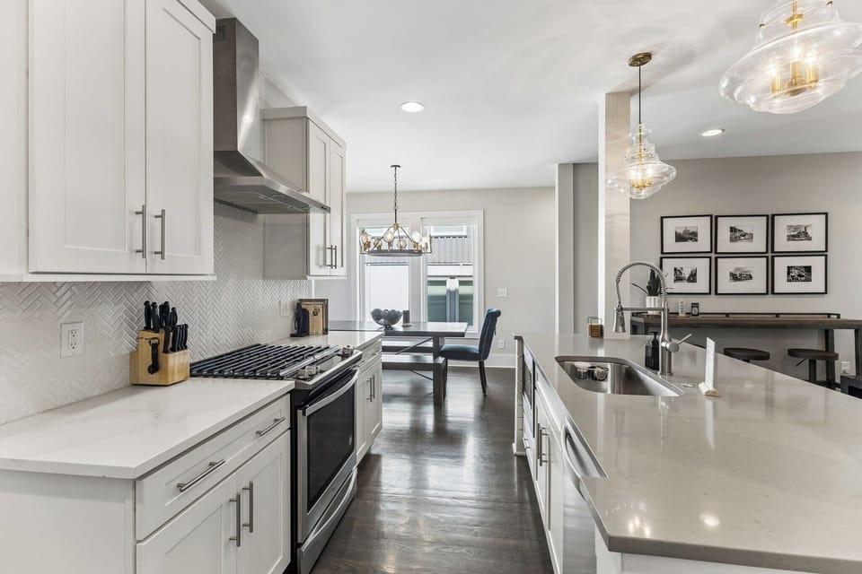 You've got a real gas range for whoever wants to cook — stainless steel burners, herringbone backsplash, and a kitchen that doesn't make you feel like you're roughing it.