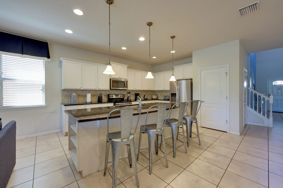 Fully equipped kitchen with island and bar chairs