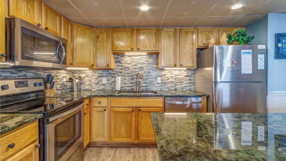 Your fully equipped kitchen features granite countertops, stainless steel appliances, and beautiful wood cabinetry for all your cooking needs.