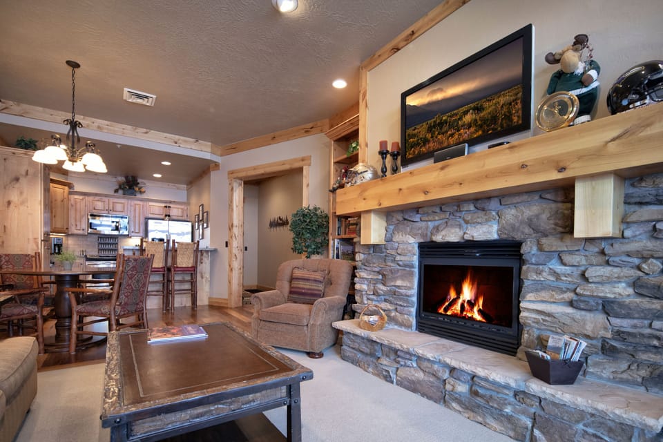 Cozy up in your rustic mountain retreat where crackling flames dance in the stone fireplace while you sip your favorite drink. The open concept connects you to the fully-equipped kitchen—perfect for creating memories with loved ones.
