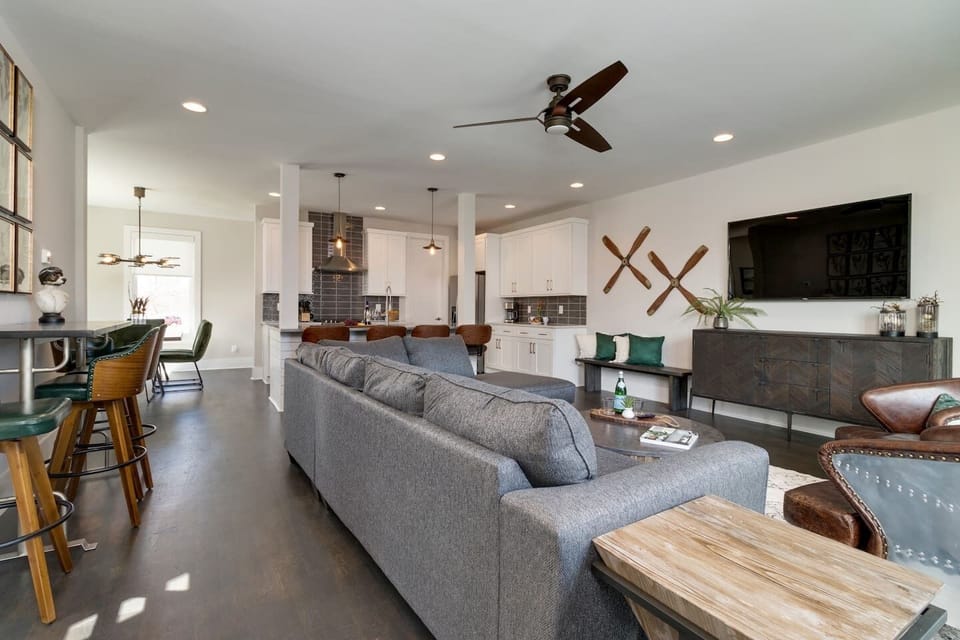 The open living area has a sectional sofa and a 65" 4K SmartTV