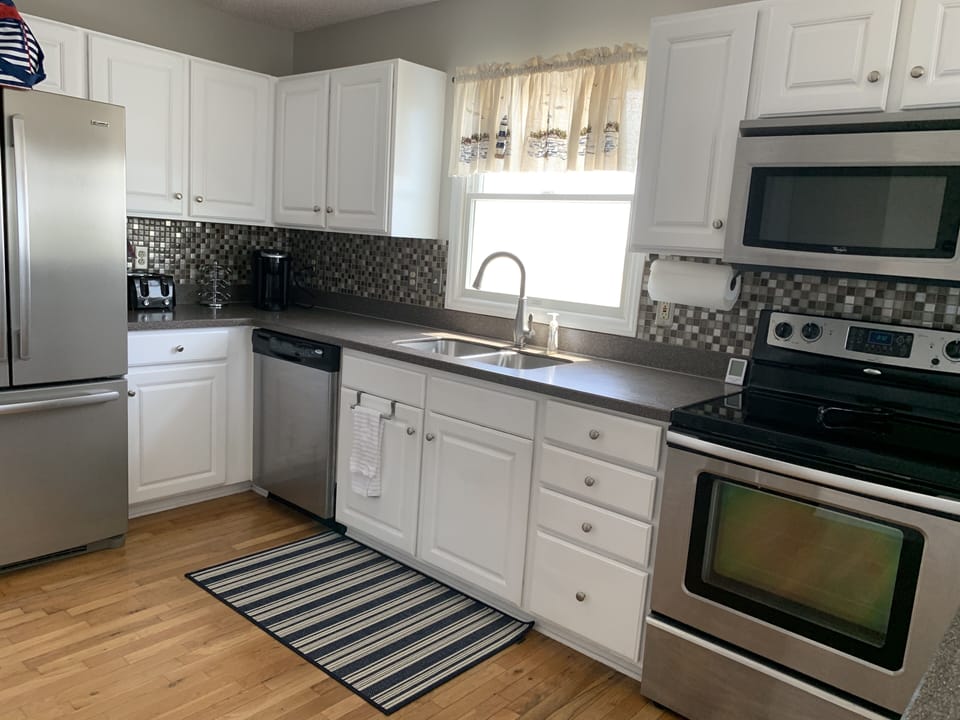 Kitchen appliances include refrigerator, dishwasher, electric stovetop and oven.