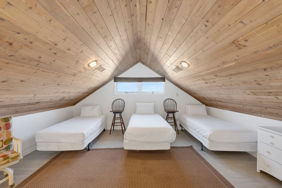 The upstairs loft has a TV and three Twin beds - sleeping 3 guests