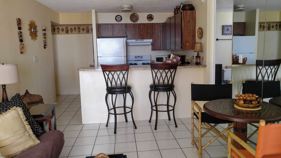 Entrance hall on the left. Full kitchen. Futon on left, dining table on right.