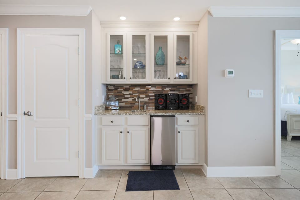 Sip refreshing beverages and entertain from this stylish wet bar with elegant glassware display and stereo system